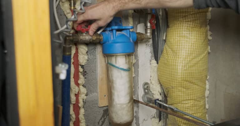 Plumber opens the water supply through the Water Filter with a new clean cartridge.
